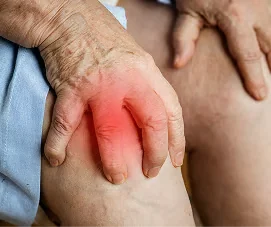 Hände einer älteren Person flach auf dem eigenen Knie abgelegt