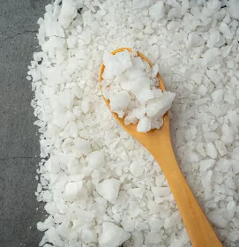 Weiße MSM Kristalle rund um einen Holzlöffel verteilt